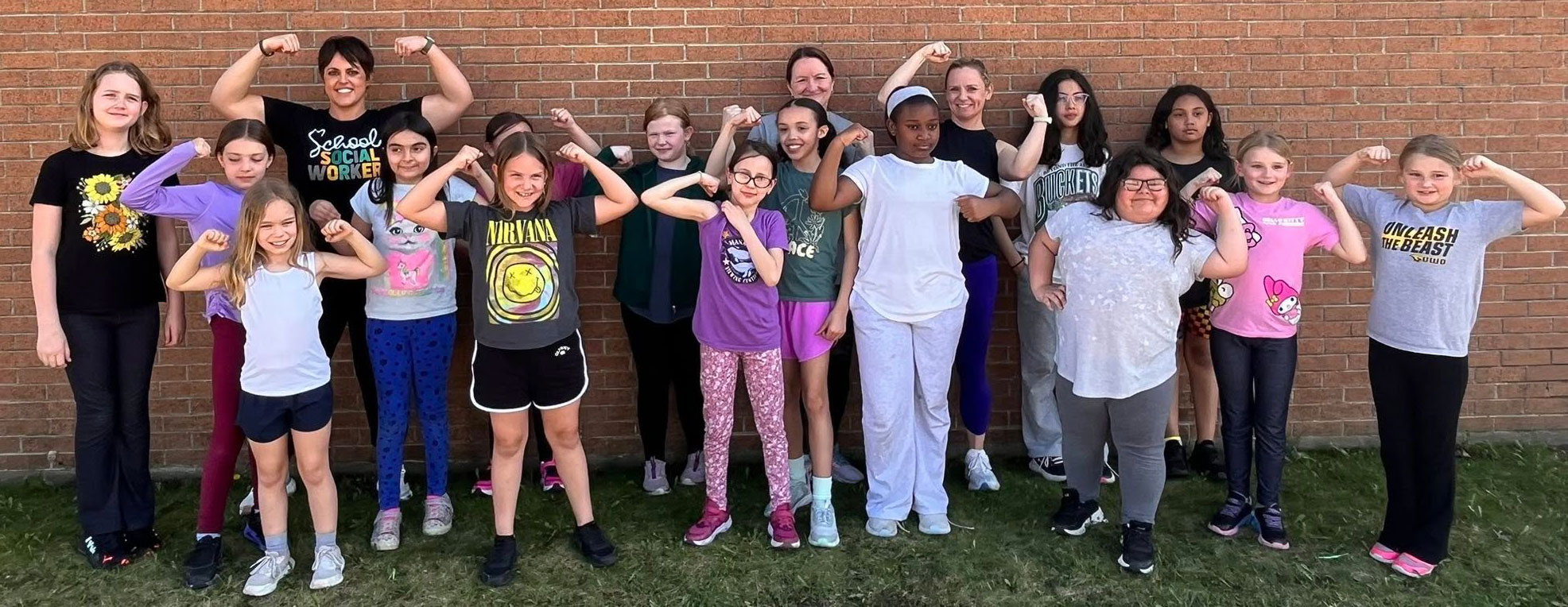 The Girls on the Run team flex their muscles.