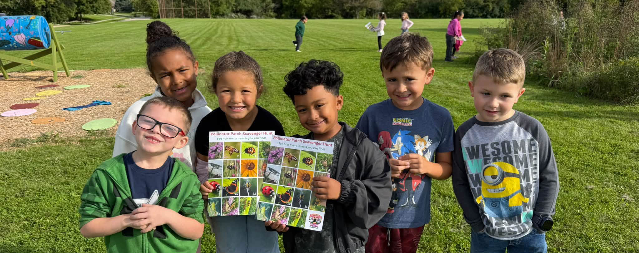 Six student posing outside after learning about pollinators, plants, and stormwater.