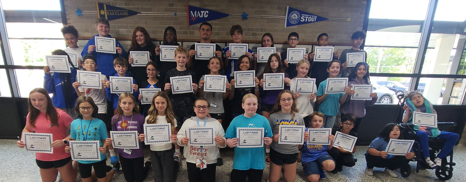 Group photo of the September students of the month. Each student is holding a certificate.