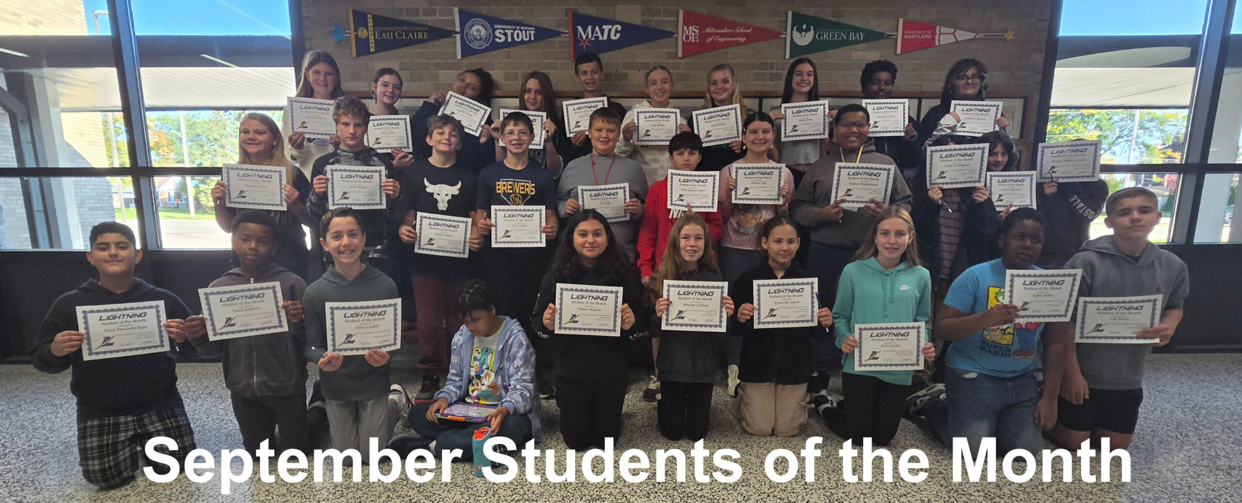 Group photo of the September students of the month. Each student is holding a certificate.