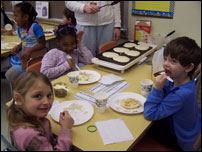 Three students eating breakfast at a table.