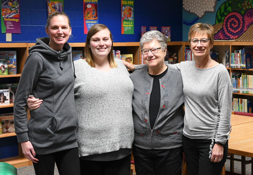 Group photo of Rachael, Debbie, Shirley and Sarah standing in a library.