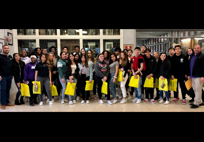 A large group photo of Indian Trail students holding yellow bags.