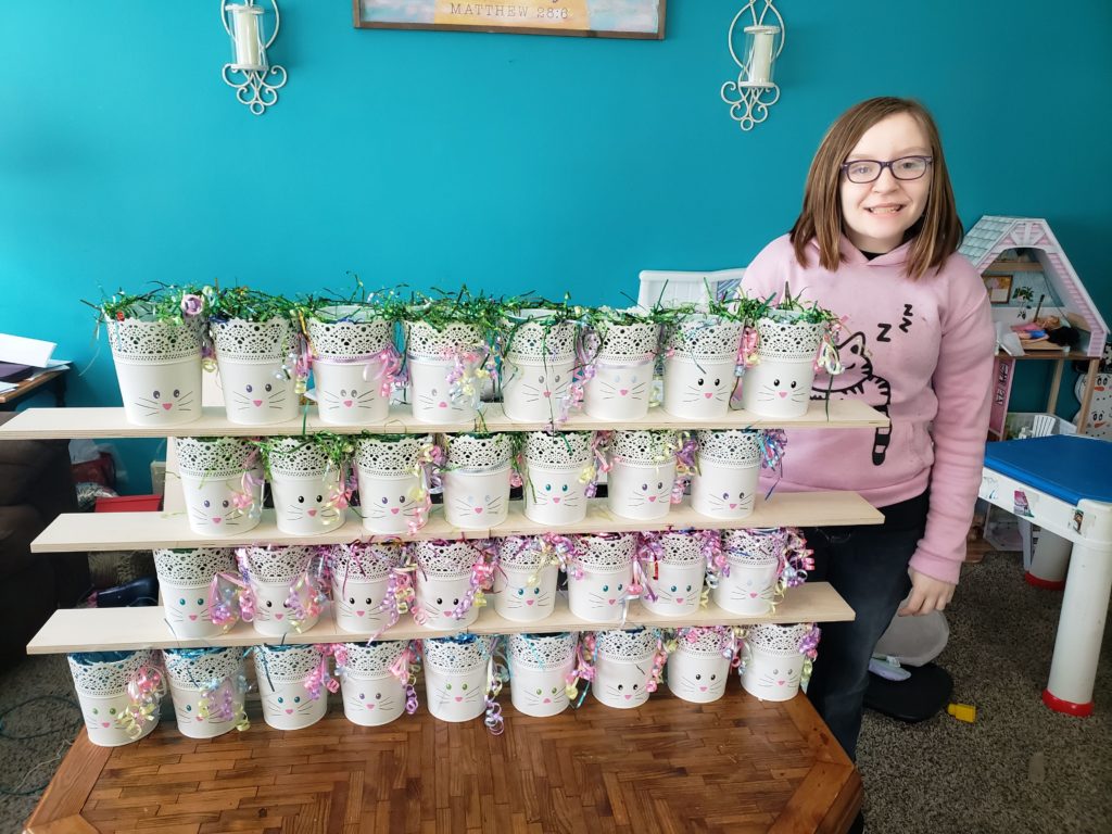 Ashleigh Ours standing next to 32 flower pots