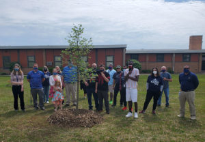 Alexzander Pearson and staff members pose next to the new tree.