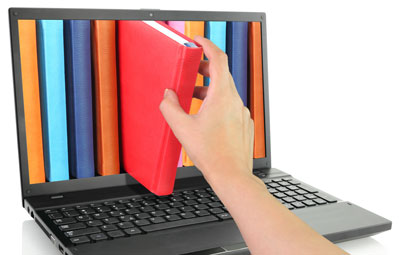 A hand pulling a book out of a laptop screen.