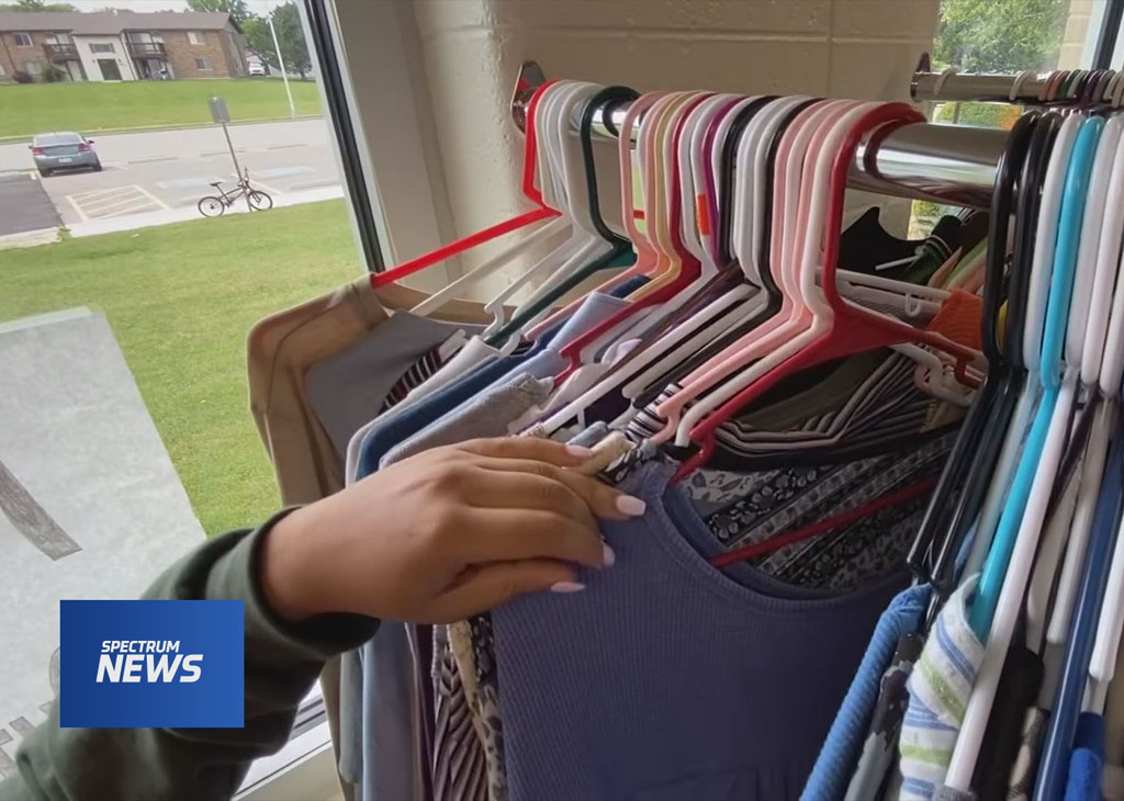 Clothing in hangers on a rack.