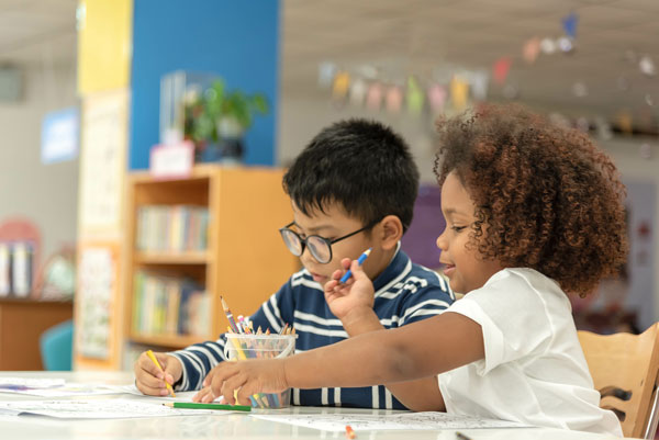 Two kindergarten students working at a table.