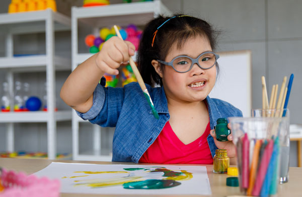 little girl sitting at desk  painting
